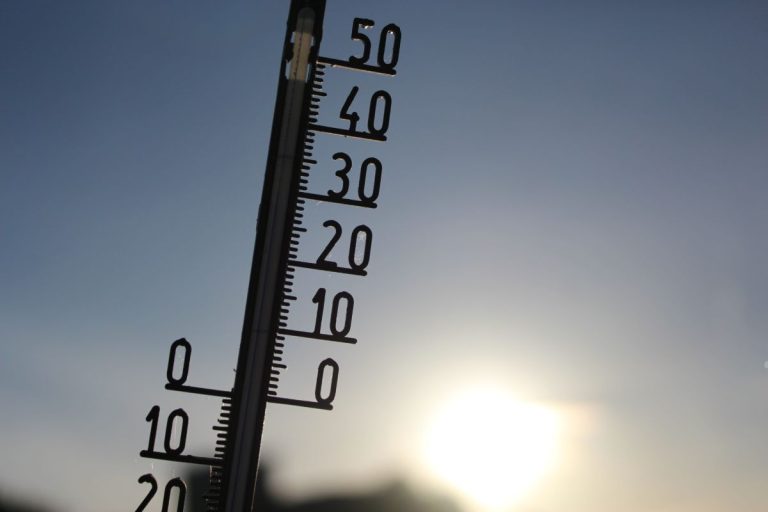 A thermometer displayed in front of the sun, illustrating the concept that high temperatures can kill mold.