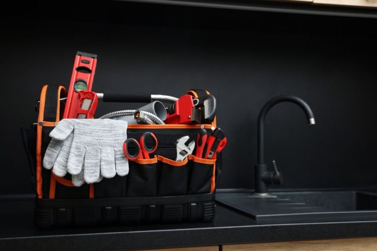 A black and orange tool bag placed on a kitchen counter, showcasing its vibrant colors against the countertop surfac